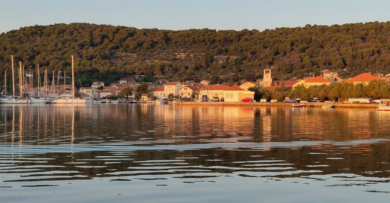 Das Foto zeigt einen Hafen mit sich einem klar spiegelnden Meer.