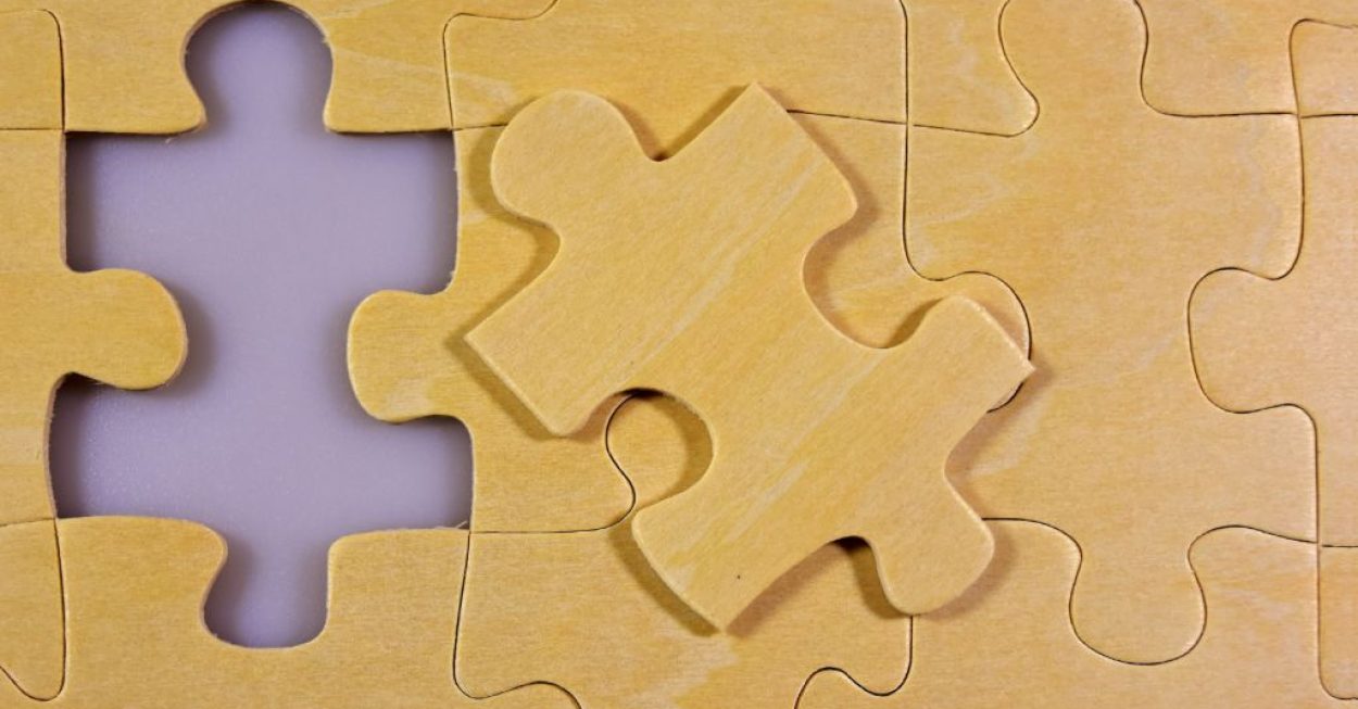 Das Bild zeigt ein Puzzlestück, das in ein Gesamtpuzzlebild passt. Es symbolisiert, dass etwas zusammenpasst.